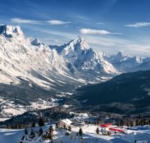 Widok na Cortina d'Ampezzo otoczoną ośnieżonymi górami.