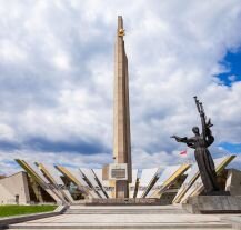 Muzeum Wielkiej Wojny Ojczyźnianej w Mińsku, z monumentalnym obeliskiem i rzeźbą "Matka Ojczyzna" na pierwszym planie.