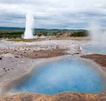 Gejzer Strokkur w Islandii w trakcie erupcji – błękitne gorące źródła i para wodna w geotermalnym obszarze Haukadalur.