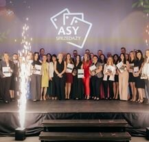 Laureaci nagrody As Sprzedaży na scenie, pozujący ze statuetkami i dyplomami podczas uroczystej gali CUK.