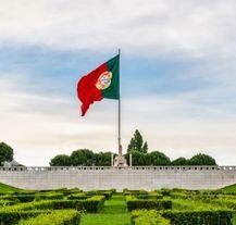 Flaga Portugalii powiewająca nad ogrodami Parku Edwarda VII w Lizbonie.